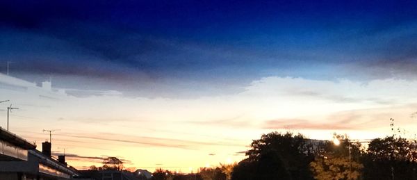 Low angle view of silhouette trees against sky