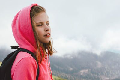 Girl in hood against mountain