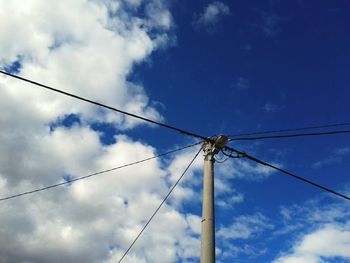 Low angle view of telephone pole against sky