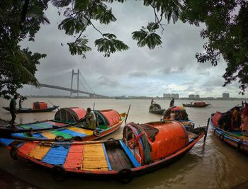 Boats moored on beach against sky