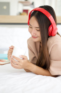Beautiful young woman drinking glasses on bed