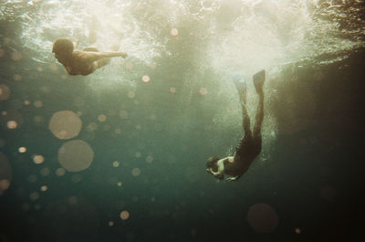 Two people free diving in nusa penida, bali, indonesia. shot on 35mm cinestill 400d film.