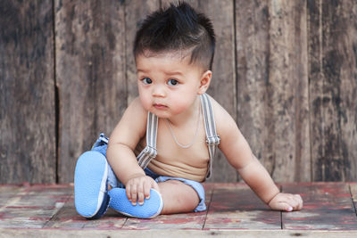 Cute baby boy against on wooden table