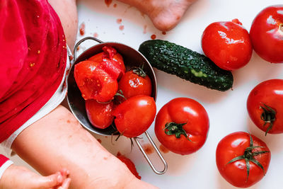 High angle view of baby with crushed tomatoes on table