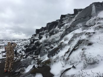 Rock formations by sea against sky