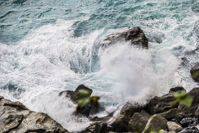 High angle view of wave splashing on rock