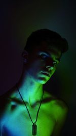 Portrait of young man against black background