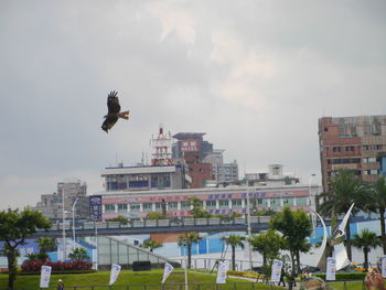 Buildings in city against cloudy sky