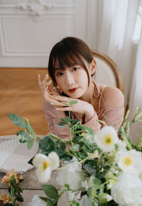 Portrait of young woman sitting on table