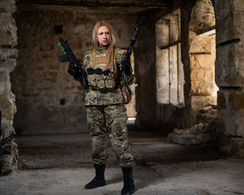 Full length of young woman standing against wall