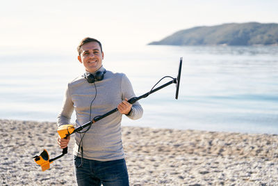 Portrait of young man standing at beach