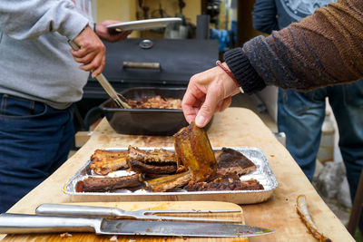 Midsection of man preparing food on barbecue grill