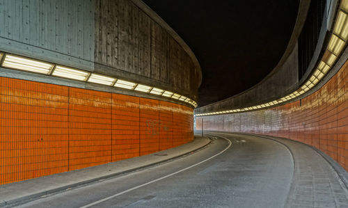 Empty road in illuminated tunnel