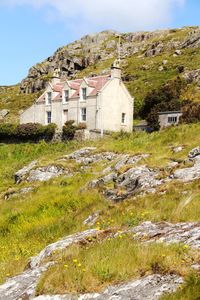 Houses by mountain against sky