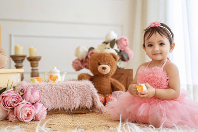 Portrait of cute girl with teddy bear at home