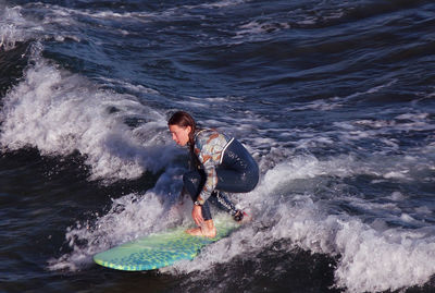 Young man surfing in sea