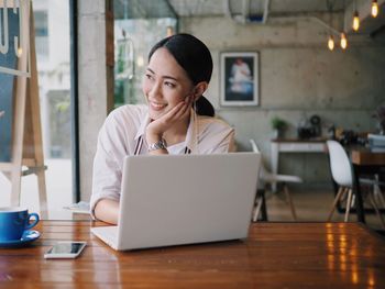 Mid adult man using mobile phone at table