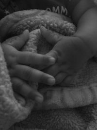 Close-up of baby hand on bed