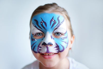 Girl aqua makeup in the form of a blue water tiger zodiac on a white background, smile portrait. 