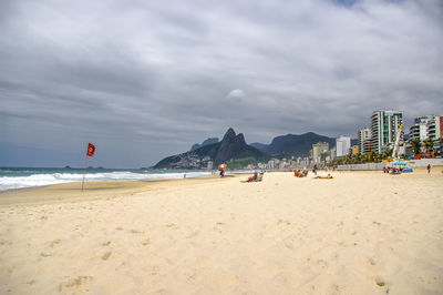 Panoramic view of people on beach against sky