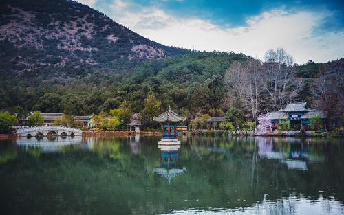 Scenic view of lake by buildings against sky