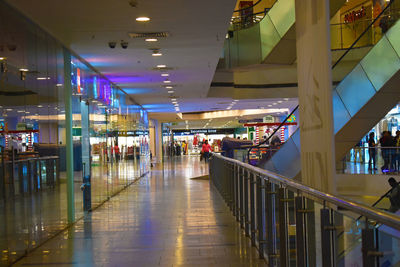 People walking on illuminated airport in city