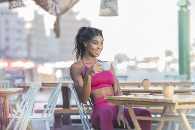 Portrait of smiling young woman sitting on table