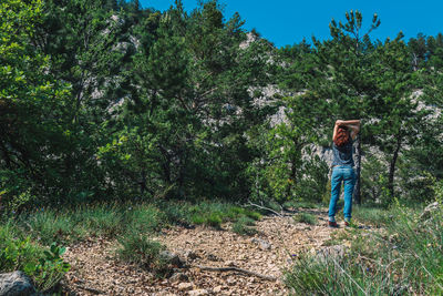 Man standing amidst trees in forest