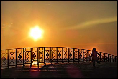 People on bridge at sunset