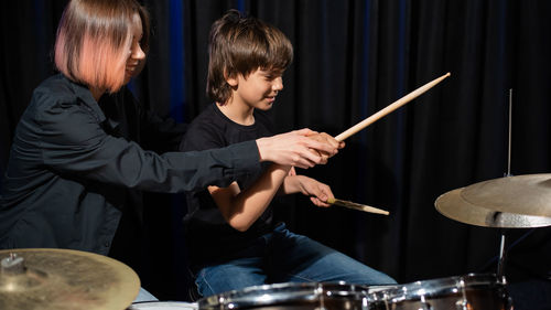 Midsection of man playing drum