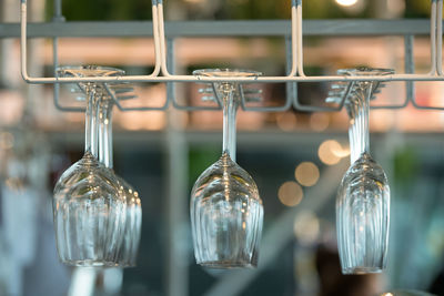 Close-up of wineglasses hanging on rack