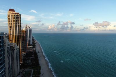 Scenic view of sea by buildings against sky