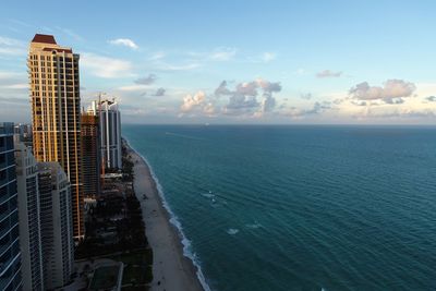 Scenic view of sea by buildings against sky