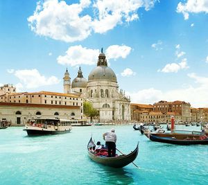 Ferry with gondolas sailing in grand canal by santa maria della salute against sky