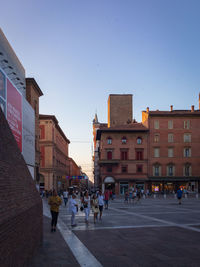 People walking on street amidst buildings in city
