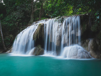 Scenic waterfall smooth stream, turquoise pond in rainforest. erawan falls, kanchanaburi, thailand.