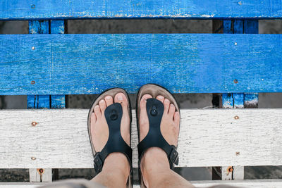 Low section of man on pier at swimming pool