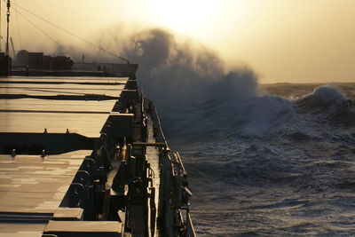 Pier over sea against sky during sunset