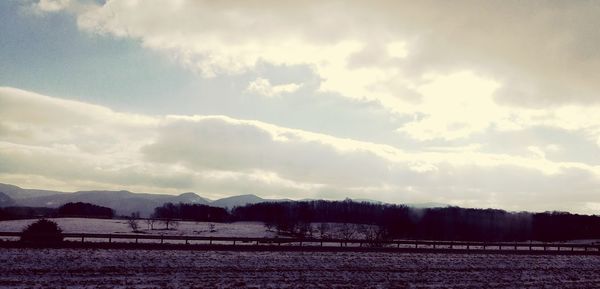 Scenic view of snowcapped field against sky