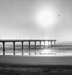 View of pier on beach against sky