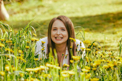 Portrait of young woman sitting on field