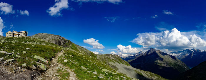 Low angle view of snowcapped mountains against blue sky