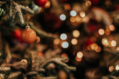 Golden shiny ball hanging on the christmas tree. new year's details in the festive atmosphere