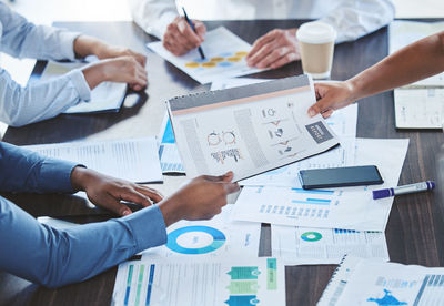 Midsection of business colleagues working on table