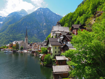 Houses in town by mountains against sky