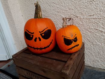 Various pumpkin on wood against orange wall during halloween