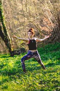 Young woman with arms raised on field