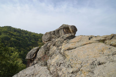 Low angle view of rocks on mountain against sky