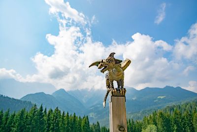 Statue on mountain against sky
