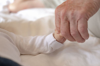 Close-up of man holding baby hand